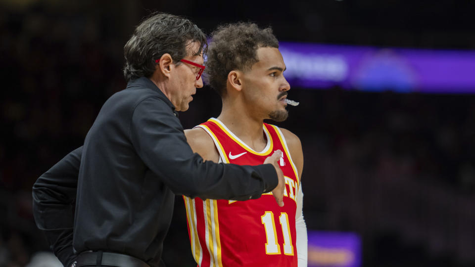 Atlanta Hawks coach Quin Snyder speak with guard Trae Young during the first half of the team's NBA basketball game against the Brooklyn Nets, Wednesday, Dec. 6, 2023, in Atlanta. (AP Photo/Hakim Wright Sr.)