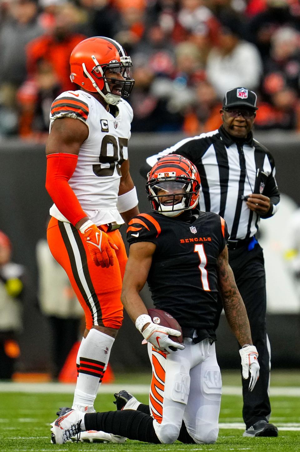 Cincinnati Bengals wide receiver Ja'Marr Chase (1) and Cleveland Browns defensive end Myles Garrett (95) laugh after Garrett sacked Chase while he attempted to throw a pass on a trick play Dec. 11, 2022, in Cincinnati.