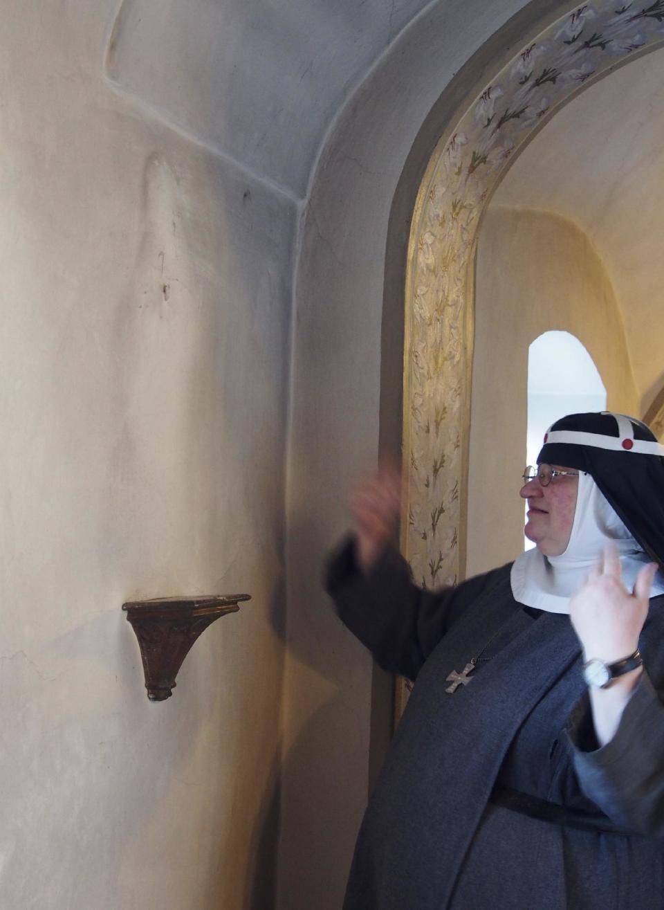 CORRECTS DETAILS ABOUT THE ABBEY In this Dec. 6, 2016 photo Sister Apollonia gestures at a shelf where once stood a statue the abbey in Altomuenster, Germany. The impending dissolution of a 15th-century monastery in Bavaria is pitting scholars against Catholic church officials. The library in Altomuenster Abbey, accessible only to the monastery’s nuns for more than five centuries, contains precious illuminated manuscripts and other treasures. Scholars worry the “holy grail” for Bridgettine Order research could be damaged, broken up or sold off before it can be catalogued and studied. (AP Photo/David Rising)