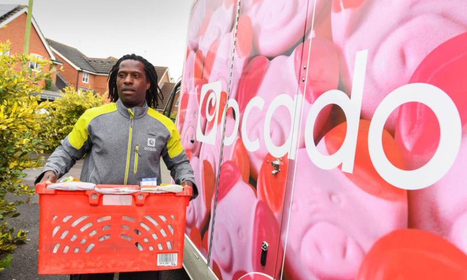 A driver delivers groceries in an Ocado Percy van.