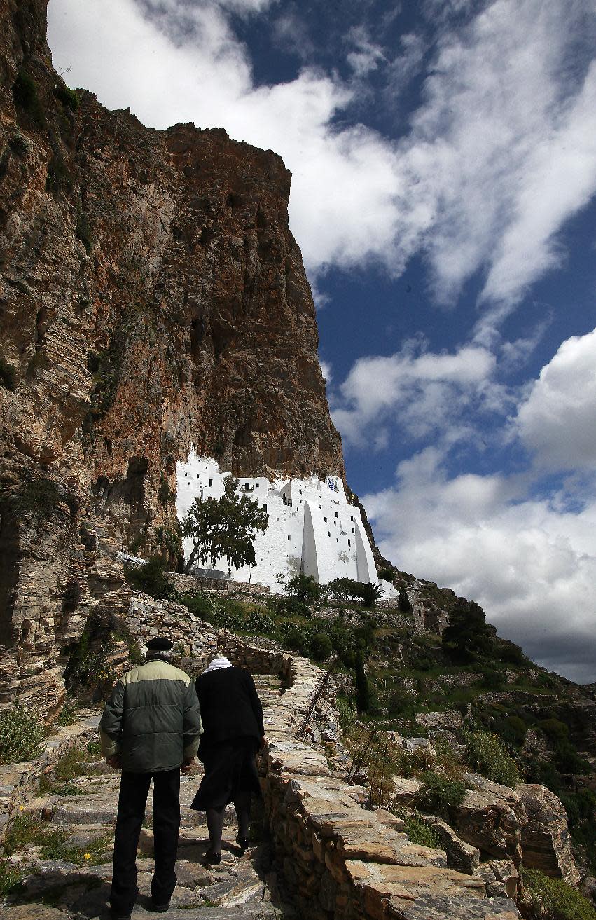 The faithful procede uphill to the 8th century Greek Orthodox monastery of Virgin Mary Hozoviotissa, to participate to the Good Friday procession, in the Greek island of Amorgos on Friday April 18, 2014. More than 250 million Orthodox Christians worldwide will celebrate Easter this year on Sunday, April 20. (AP Photo/Dimitri Messinis)