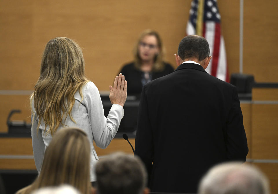 Molly Corbett, left, swears on the Bible as she pleads no contest to voluntary manslaughter during a hearing, Monday, Oct. 30, 2023, for Molly Corbett and her father, Thomas Martens, in the 2015 death of Molly's husband, Jason Corbett, at the Davidson County Courthouse in Lexington, N.C. (Walt Unks/The Winston-Salem Journal via AP, Pool)