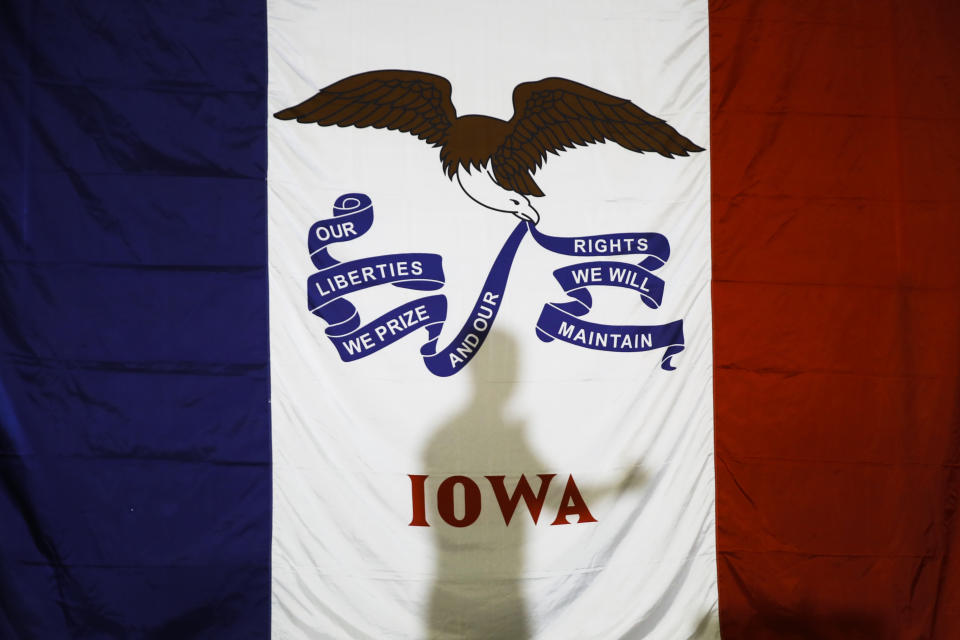 Democratic presidential candidate former South Bend, Ind., Mayor Pete Buttigieg's shadow is cast on the Iowa state flag as he speaks during a campaign event at Northwest Junior High, Sunday, Feb. 2, 2020, in Coralville, Iowa. (AP Photo/Matt Rourke)