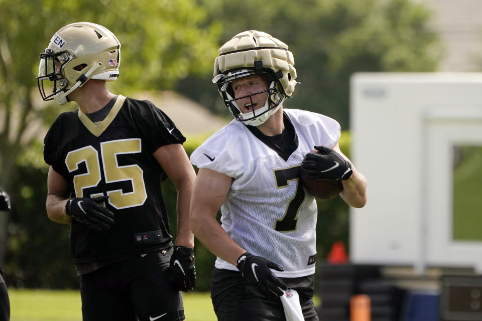 New Orleans Saints quarterback Taysom Hill (7) runs through drills with safety Daniel Sorensen (25) during the NFL football team's training camp in Metairie, La., Wednesday, July 27, 2022. (AP Photo/Gerald Herbert)