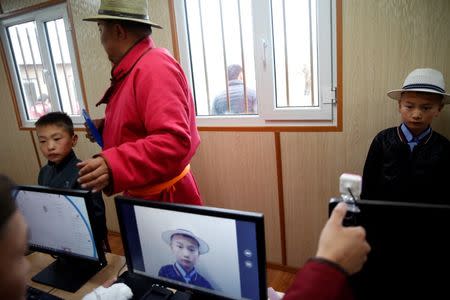 Child jockeys have their pictures taken and fingerprints registered before taking part in horse races at the Mongolian traditional Naadam festival, on the outskirts of Ulaanbaatar, Mongolia July 11, 2018. Picture taken July 11, 2018. REUTERS/B. Rentsendorj