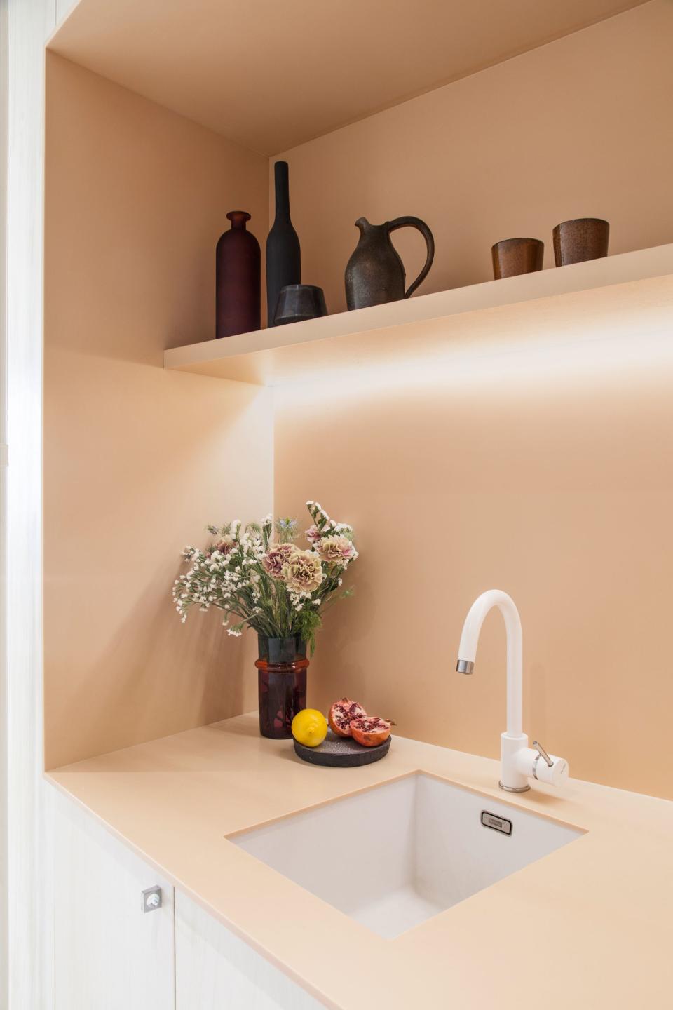 LED strip lighting in the kitchen is minimal and effective. The shelf was painted to match the color of the Corian.