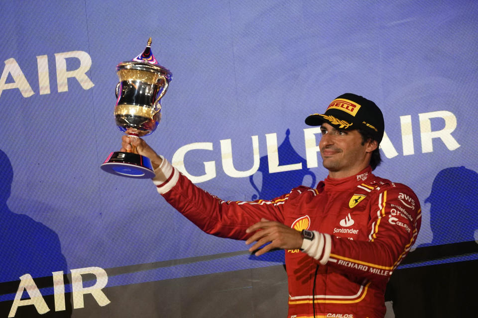 Third place, Ferrari driver Carlos Sainz of Spain holds up his trophy on the podium during the Formula One Bahrain Grand Prix at the Bahrain International Circuit in Sakhir, Bahrain, Saturday, March 2, 2024. (AP Photo/Darko Bandic)
