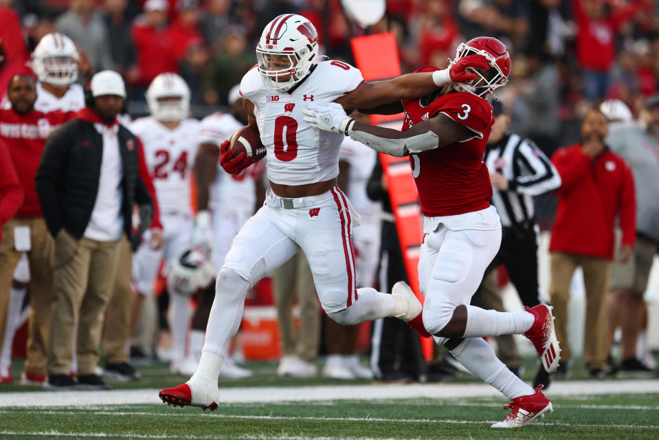 PISCATAWAY, NJ – NOVEMBER 06 : Braelon Allen #0 of the Wisconsin Badgers stiff arms Olakunle Fatukasi #3 of the <a class="link " href="https://sports.yahoo.com/ncaaw/teams/rutgers/" data-i13n="sec:content-canvas;subsec:anchor_text;elm:context_link" data-ylk="slk:Rutgers Scarlet Knights;sec:content-canvas;subsec:anchor_text;elm:context_link;itc:0">Rutgers Scarlet Knights</a> on a run during the second half of a game at SHI Stadium on November 6, 2021 in Piscataway, New Jersey. Wisconsin defeated Rutgers 52-3. (Photo by Rich Schultz/Getty Images)