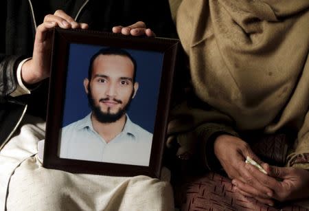 Muhammad Azeem (L) and Sajida Parveen, the parents of Ehsan Azeem, who was sentenced to death by a military court, hold their son's picture during an interview with Reuters in Rawalpindi January 23, 2015. REUTERS/Faisal Mahmood