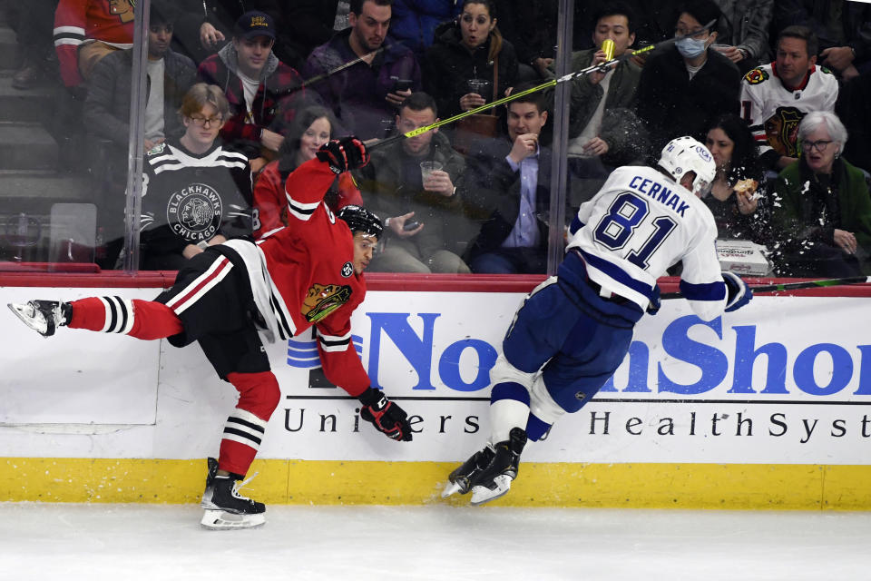 Chicago Blackhawks defenseman Caleb Jones (82) is checked by Tampa Bay Lightning defenseman Erik Cernak (81) during the second period of an NHL hockey game, Sunday, March 6, 2022, in Chicago. (AP Photo/Matt Marton)