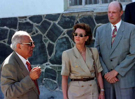 FILE PHOTO: Norway's King Harald and Queen Sonja talk to former political prisoner Ahmed Kathrada (L) outside the cell once occupied by President Nelson Mandela on Robben Island February 26, 1998. REUTERS/File Photo