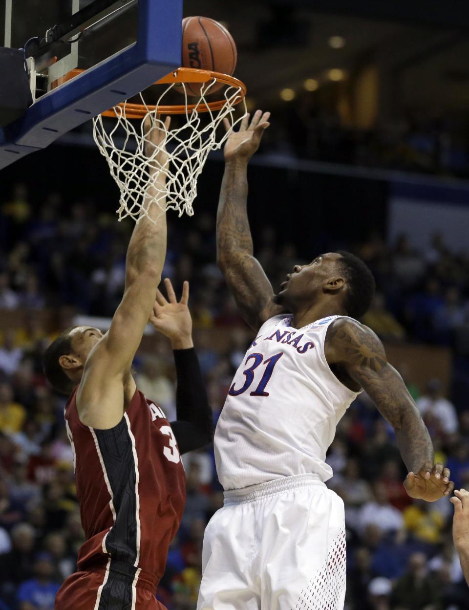 Kansas' Jamari Traylor, right, heads to the basket as Stanford's Dwight Powell defends during the first half of a third-round game of the NCAA college basketball tournament Sunday, March 23, 2014, in St. Louis. (AP Photo/Jeff Roberson)