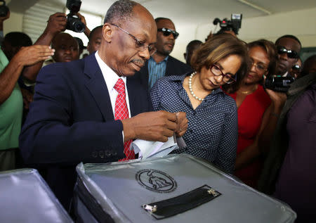 Former President Jean-Bertrand Aristide (L) casts his ballot next to his wife Mildred Trouillot-Aristide and presidential candidate Maryse Narcisse in the presidential elections in Port-au-Prince, Haiti, November 20, 2016. REUTERS/Jeanty Junior Augustin