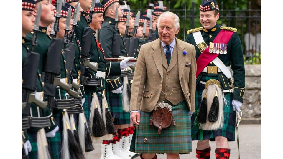 King Charles wearing kilt at gates of Balmoral