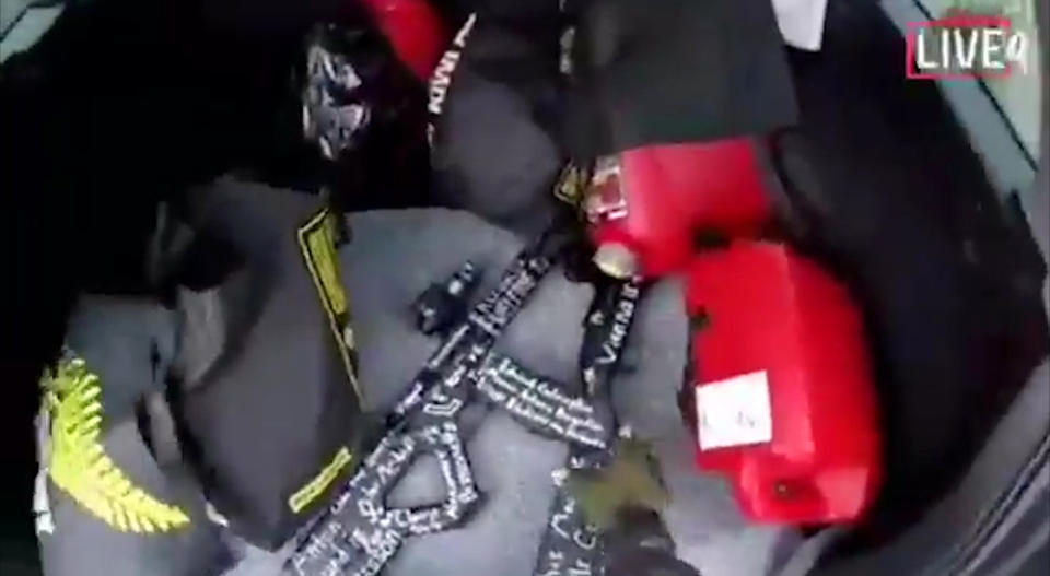 FILE - In this file image made from video that was live-streamed Friday, March 15, 2019, a gunman reaches for guns in the back of his car before the mosque shootings in Christchurch, New Zealand. Only a week after attacks on two mosques in New Zealand killed 50 worshippers, the country has banned sales of "military-style" semi-automatic weapons and high-capacity magazines. (Shooter's Video via AP, File)