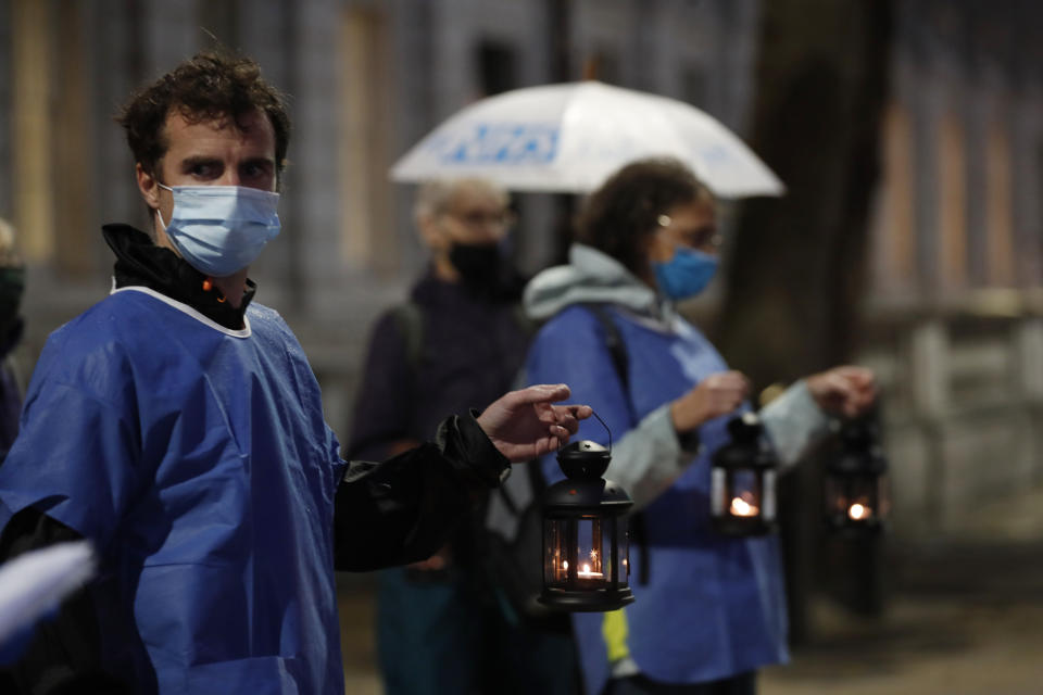 Campaigners hold lanterns outside Downing Street for British NHS medical and care workers who have died due to COVID-19, in London, Friday, July 3, 2020. A number of NHS staff and campaigners carried one lantern to represent people who have died due to COVID-19, as they walked from St. Thomas' Hospital over Westminster Bridge to then hold a candlelit vigil outside Downing Street, where they read out a small number of representative names of NHS staff who died. (AP Photo/Alastair Grant)