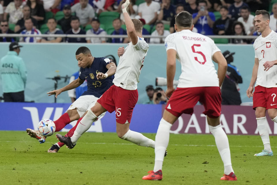 France's Kylian Mbappe, left, scores his side's third goal during the World Cup round of 16 soccer match between France and Poland, at the Al Thumama Stadium in Doha, Qatar, Sunday, Dec. 4, 2022. (AP Photo/Ricardo Mazalan)