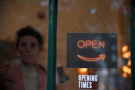 A woman stands behind a branded sign on the door of Amazon's Black Friday pop-up space in London, Britain, November 21, 2017. REUTERS/Toby Melville