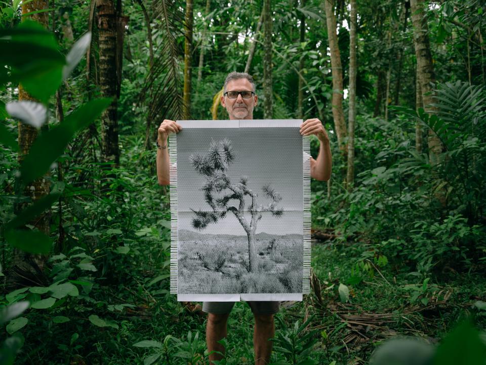 Argentine-American artist Marcelo Bengoechea holds up "Karma Tree #4," which he finished weaving in the rain forest of Sri Lanka.
