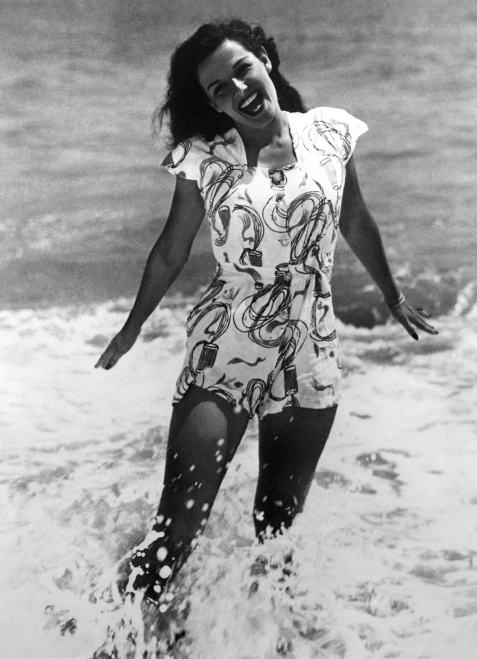 Russell frolicking in the water wearing a romper-like ensemble sometime in 1940.&nbsp;