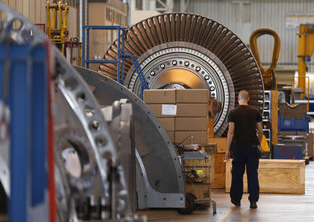 A worker walks past a gas turbine under construction at the gas turbines production unit of the General Electric plant in Belfort, June 24, 2014. REUTERS/Vincent Kessler/File Photo