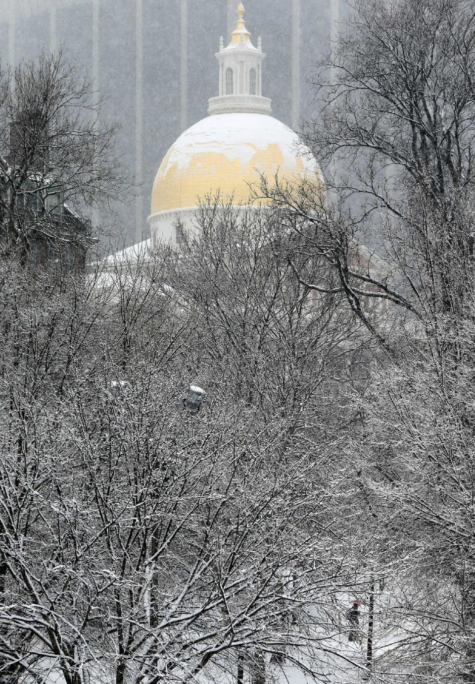 Snow covers the golden dome on the Statehouse in Boston, Tuesday, Feb. 18, 2014. It was expected to drop 3 to 5 inches of snow on Boston, with 6 to 10 inches forecast for parts of Northern New England, before moving out late Tuesday and early Wednesday. (AP Photo/Michael Dwyer)