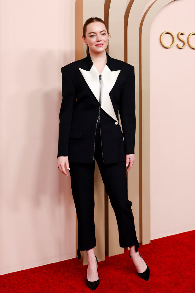 Emma Stone in a black and white asymmetrical blazer and trousers on the Oscars red carpet