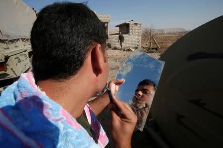 A Syrian Kurdish fighter shaves in the town of Bashiqa, after it was recaptured from the Islamic State, east of Mosul, Iraq, November 12, 2016. Picture taken November 12, 2016. REUTERS/Azad Lashkari