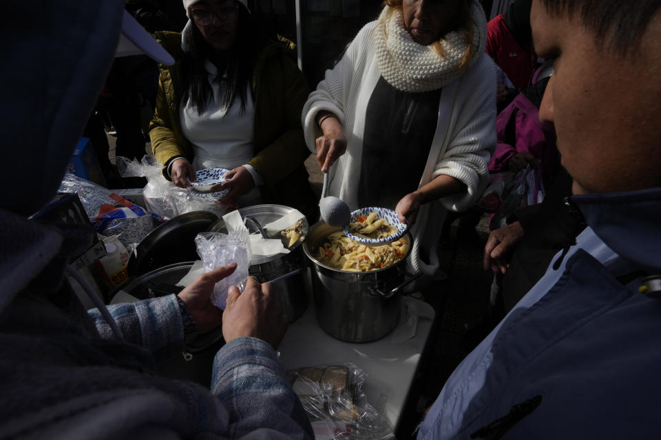 A meal is served to migrants, Wednesday, Nov. 1, 2023, near a Northside police station where they live in a small tent community in Chicago. (AP Photo/Charles Rex Arbogast)