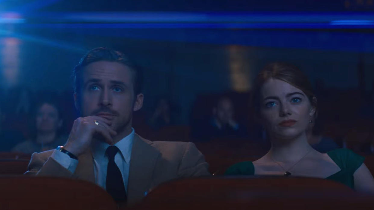 Ryan Gosling and Emma Stone bask in the glow of the cinema screen in 'La La Land'. (Credit: Lionsgate)