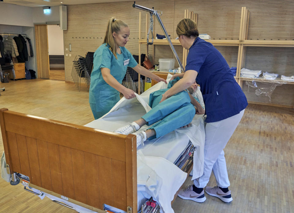 Former Scandinavian Airlines flight attendants learn basic skills on to assist in nursing homes and hospitals due to the coronavirus outbreak, in Stockholm, Wednesday, April 1, 2020. The airline announced in mid-March the temporary layoff of up to 10,000 employees, 90% of its workforce amid a drop in demand for international travel as governments clamped down on public events to contain the virus outbreak. With the help of a foundation, it is one of several airlines offering former staff the chance to work on the front line of the pandemic. (AP Photo/David Keyton)