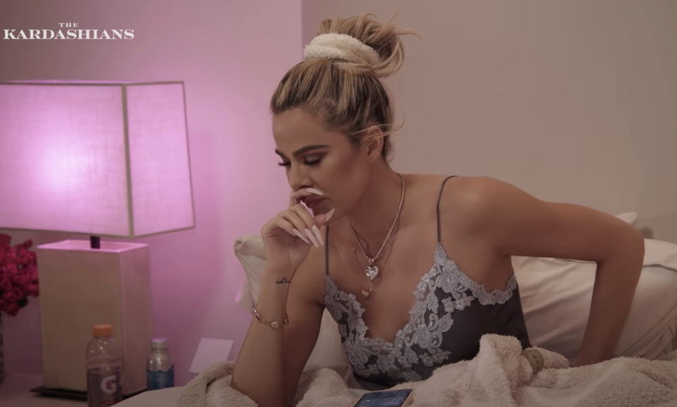 Close-up of Khloé sitting up in a bed