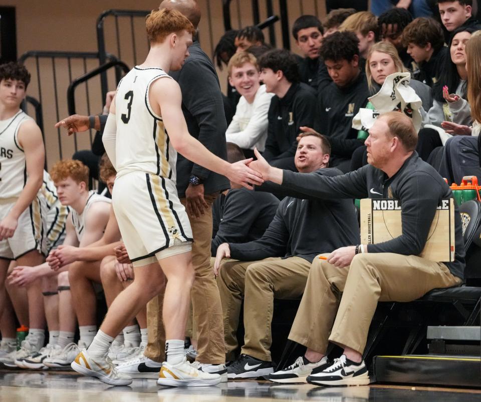 Noblesville Millers Aaron Fine (3) high-fives his dad assistant coach Matt Fine on Tuesday, Feb. 20, 2024, ahead of the game against Mississinewa at Noblesville High School in Noblesville.