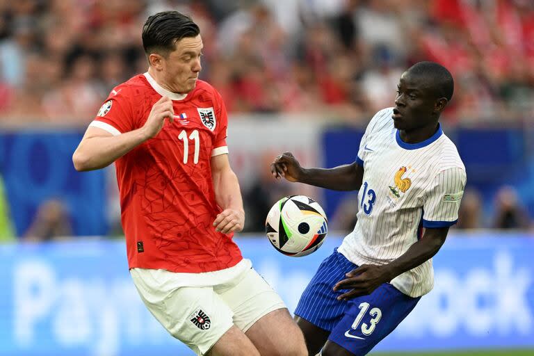 Austria's forward #11 Michael Gregoritsch fights for the ball with France's midfielder #13 N'Golo Kante during the UEFA Euro 2024 Group D football match between Austria and France at the Duesseldorf Arena in Duesseldorf on June 17, 2024. (Photo by PATRICIA DE MELO MOREIRA / AFP)