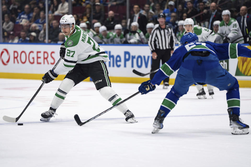 Dallas Stars' Mason Marchment (27) is defended by Vancouver Canucks' Tyler Myers (57) during the second period of an NHL hockey game Saturday, Nov. 4, 2023, in Vancouver, British Columbia. (Ethan Cairns/The Canadian Press via AP)