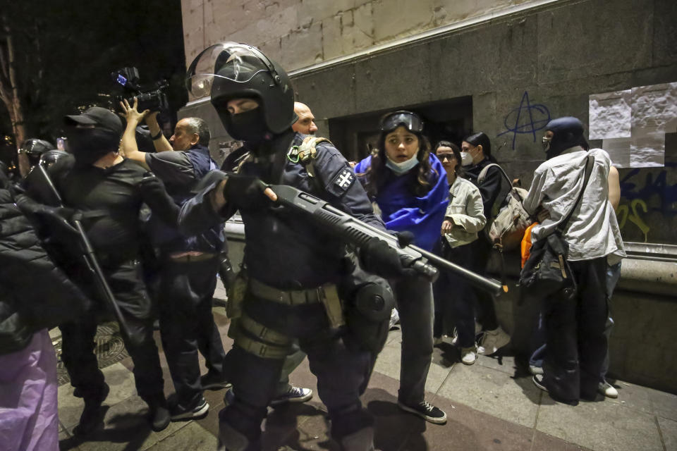 Riot policemen stand ready to fire gas grenade during an opposition protest against "the Russian law" near the Parliament building in Tbilisi, Georgia, on Wednesday, May 1, 2024. Clashes erupted between police and opposition demonstrators protesting a new bill intended to track foreign influence that the opposition denounced as Russia-inspired. (AP Photo/Zurab Tsertsvadze)