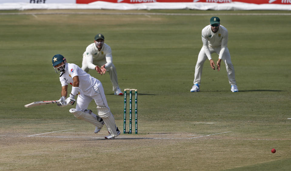 Pakistan's batsman Mohammad Rizwan, left, follows the ball after playing a shot while South Africa's Faf du Plessis, right, and Aiden Markram watches during the second day of the first cricket test match between Pakistan and South Africa at the National Stadium, in Karachi, Pakistan, Wednesday, Jan. 27, 2021. (AP Photo/Anjum Naveed)