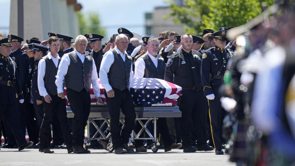 The casket of Santaquin Police Sgt. Bill Hooser is carried from Utah Valley University Monday, May 13, 2024, in Orem, Utah. Hooser was killed on May 5, 2024, while helping a Utah Highway Patrol trooper with a traffic stop when police say a man driving a semi-trailer intentionally hit Hooser. (AP Photo/Rick Bowmer)