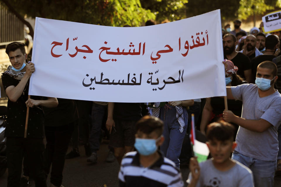 Protesters carry an Arabic banner that reads: "Save the Sheikh Jarrah neighborhood, Freedom for Palestine," during a protest in support of Palestinians in the latest round of violence in Israel, in Beirut, Lebanon, Tuesday, May 11, 2021. A confrontation between Israel and Hamas sparked by weeks of tensions in contested Jerusalem escalated Tuesday. Israel unleashed new airstrikes on Gaza, killing a number of militants and civilians, while militants barraged southern Israel with hundreds of rockets, killing two Israelis. (AP Photo/Hussein Malla)