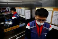 Jeong, a parcel delivery worker for CJ Logistics, holds a package as he rides elevator in Gwangju