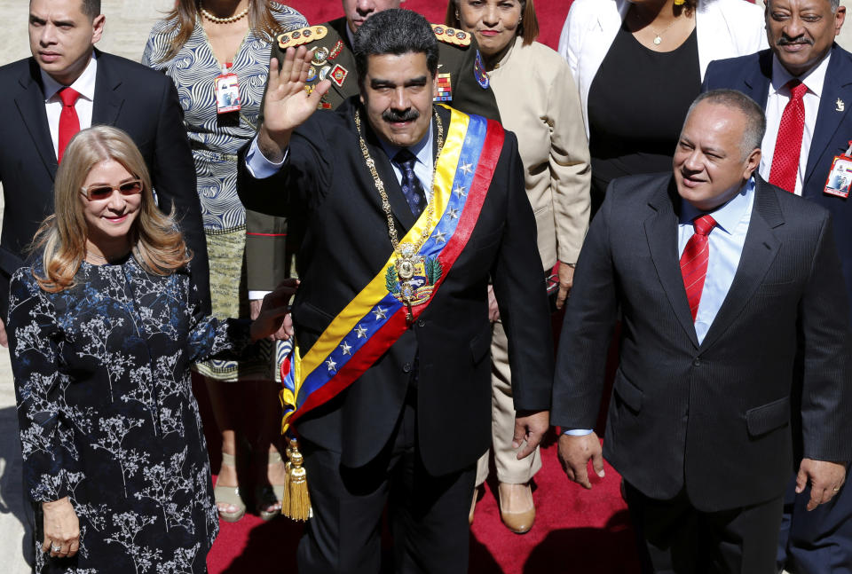 Venezuela's President Nicolas Maduro waves as he arrives with first lady Cilia Flores and Constitutional Assembly President Diosdado Cabello to the National Assembly where he will give his annual address to the nation, before members of the Constitutional Assembly in Caracas, Venezuela, Monday, Jan. 14, 2019. (AP Photo/Ariana Cubillos)