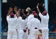 West Indies team celebrates the wicket of David Warner of Australia during the first day of the second-of-three Test matches between Australia and West Indies April 15, 2012 at Queen's Park Oval in Port of Spain, Trinidad. AFP PHOTO/Stan HONDA (Photo credit should read STAN HONDA/AFP/Getty Images)