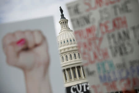 Protest signs are seen during a rally against the Republican tax bill on Capitol Hill in Washington, U.S., November 15, 2017. REUTERS/Aaron P. Bernstein/Files