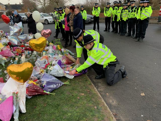 Officers from West Midlands Police lay bouquets of flowers near the scene in Babbs Mill Park