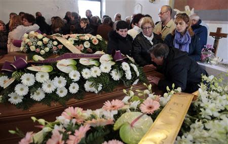 Relatives stand around three coffins during a funeral service for some victims of an extreme rainfall at Tempio Pausania on Sardinia island November 20, 2013. REUTERS/Tony Gentile