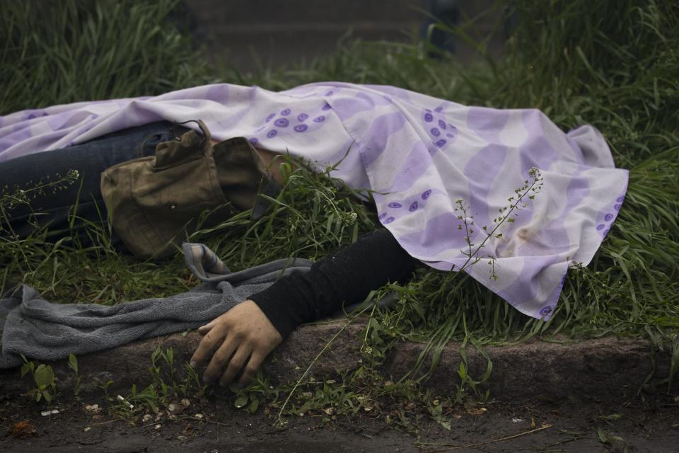 The body of a person killed during fighting between government forces and insurgents lies outside a police station in Mariupol, eastern Ukraine, Friday, May 9, 2014. Fighting exploded Friday in Mariupol, a city of 500,000 on the Sea of Azov that is on the main road between Russia proper and Crimea. The fighting between government forces and insurgents in Mariupol left several people dead. (AP Photo/Alexander Zemlianichenko)