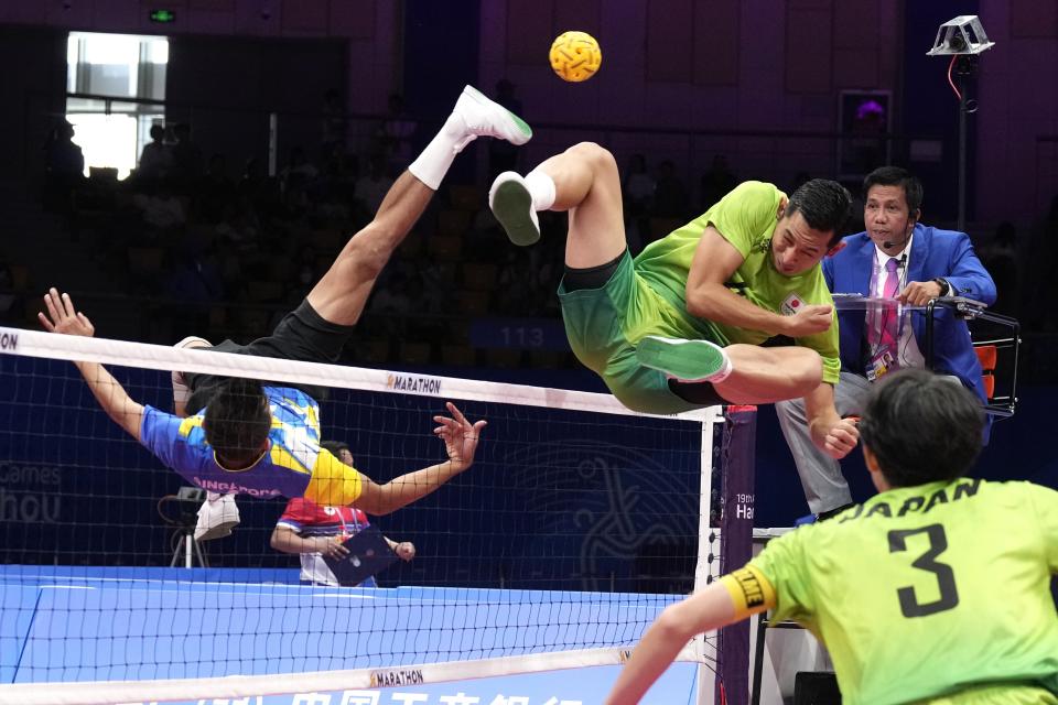 Japan's Toshitaka Naito returns the ball against Singapore during men's sepaktakraw Group B preliminary match at Jinhua Sports Centre at the 19th Asian Games in Jinhua, China, Jinhua, Monday, Oct. 2, 2023. (AP Photo/Eugene Hoshiko)