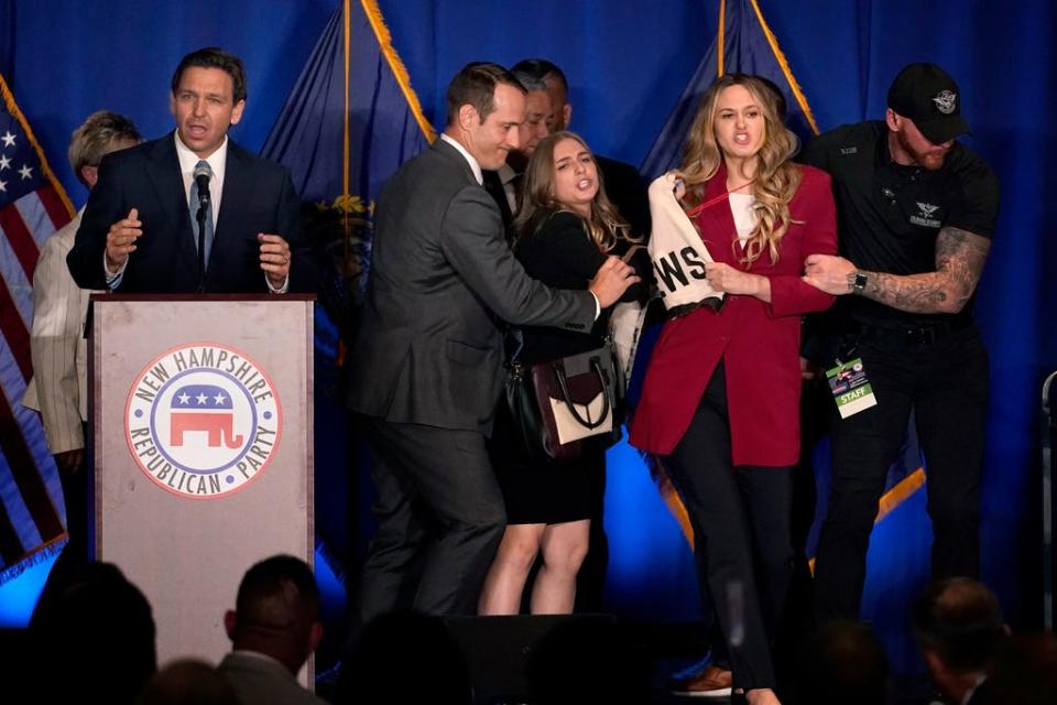 A protester interrupts an address by Florida Gov. Ron DeSantis during a stop at a New Hampshire Republican Party dinner, Friday, April 14, 2023, in Manchester, N.H.