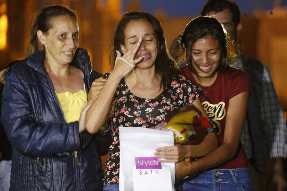 Karen Palacios, center, is helped by family members after she was released from prison at Los Teques on the outskirts of Caracas, Venezuela, Tuesday, July 16, 2019. Palacios who plays the clarinet and was cut from the National Philharmonic for criticizing the government, was detained for 6 weeks. (AP Photo/Ariana Cubillos)