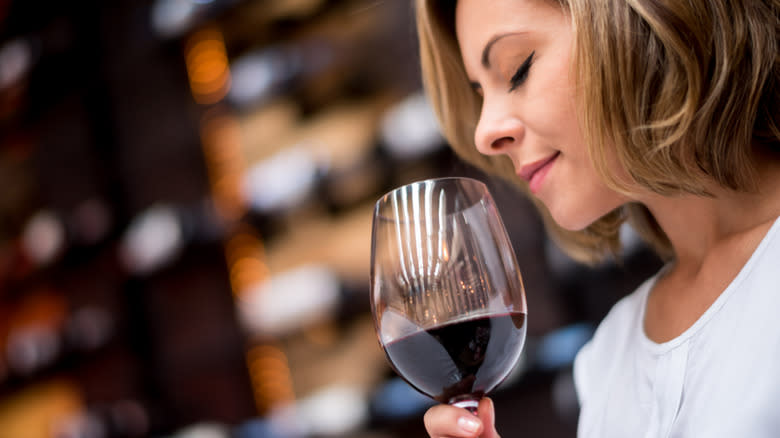 woman sniffing red wine